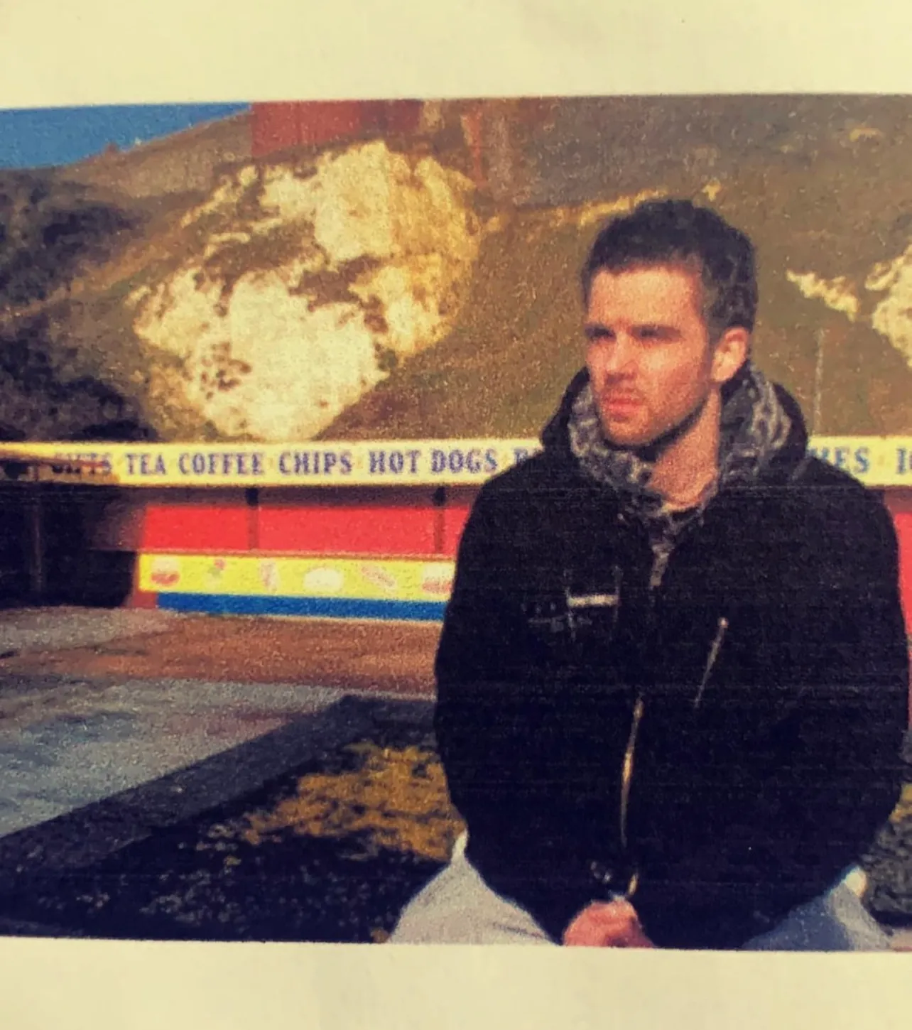 A grainy photograph of Dave as a young man by the sea